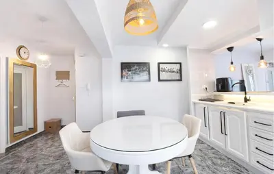 a white kitchen with a white table and chairs at Marisol Molina in Sueca