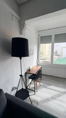 a living room with a table and a desk at Apartamento con piscina, playa y cerca de Valencia in Puebla de Farnals