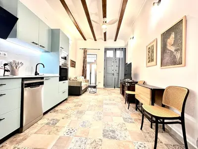 a kitchen with white cabinets and a table and chairs at Season apartment Cabañal in Valencia
