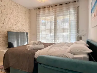 a bedroom with a large bed with a blue couch at Reinapart Patacona Beach Sunrise in Valencia