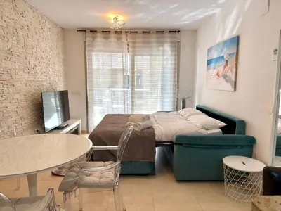 a bedroom with a bed and a couch and a table at Reinapart Patacona Beach Sunrise in Valencia