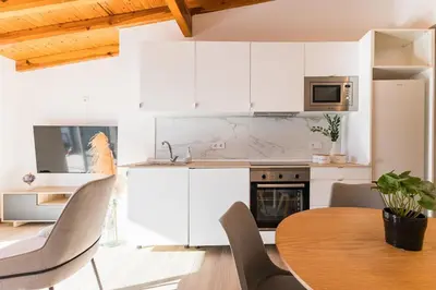 a kitchen with white cabinets and a wooden table at Loft Sayulita Escapada moderna en el paraíso in Torrent