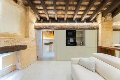a living room with a white couch and a brick wall at GMG Apartments & Suites in Valencia