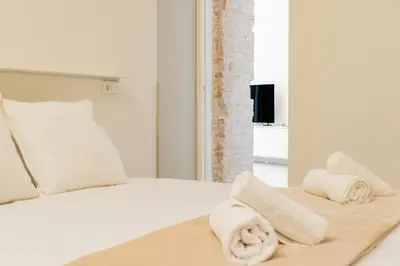 a bedroom with a bed with towels on it at GMG Apartments & Suites in Valencia