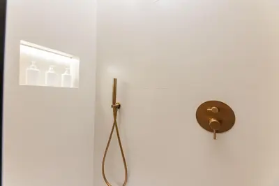 a bathroom with a shower with a mirror and a toilet at GMG Apartments & Suites in Valencia