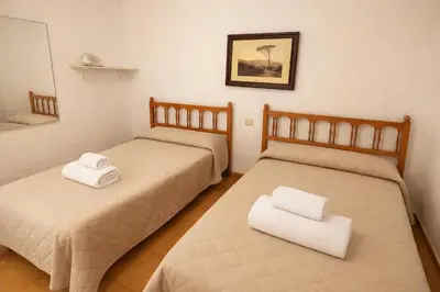 two beds in a room with white towels on them at Winahost Casita Tavernes de Valldigna in Tavernes de Valldigna