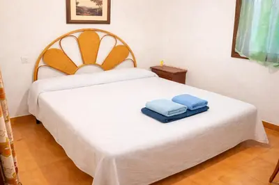 a bedroom with a white bed with two blue towels on it at Winahost Casita Tavernes de Valldigna in Tavernes de Valldigna