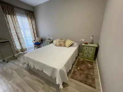a bedroom with a bed and a dresser and a window at Cabañal Flat, Wi-Fi & AACC in Valencia