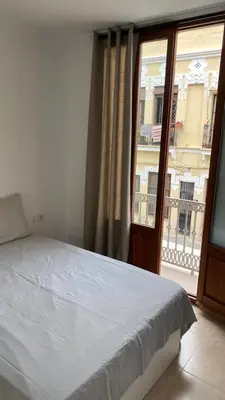 a bedroom with a bed and a large window at Cabanyal Apartment in Valencia