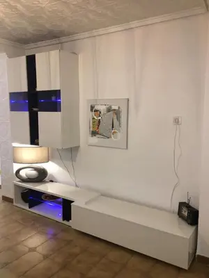 a living room with a white wall with a couch at Charming beachfront apartment in Puerto de Sagunto