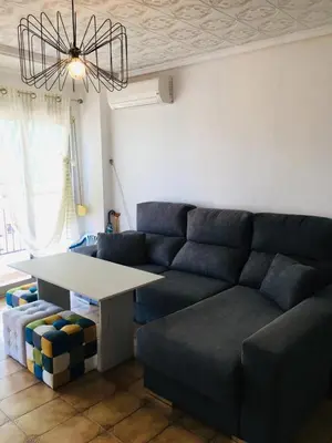 a living room with a couch and a table at Charming beachfront apartment in Puerto de Sagunto
