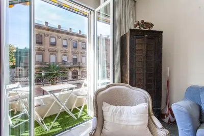 a room with a balcony with a chair and a window at Apartment Ruzafa Zapadores in Valencia