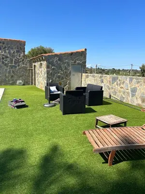 a patio with chairs and a table on grass at Villa Noelia in Turís