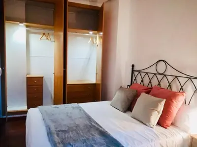 a bedroom with a large bed with red pillows at Historic city center in Valencia