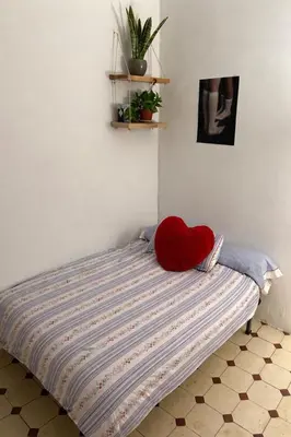 a bed with a red heart pillow on top of it at Alquiler Hab Centro Valencia in Valencia