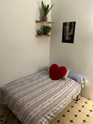a bed with a red heart pillow on it at Alquiler Hab Centro Valencia in Valencia