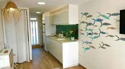 a kitchen with white cabinets and a counter top at Loft con encanto junto al mar in Barrio-Mar