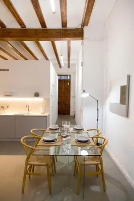 a dining room with a glass table and chairs at Can Turia in Valencia