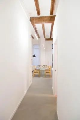 a hallway leading to a dining room with white walls and a table at Can Turia in Valencia