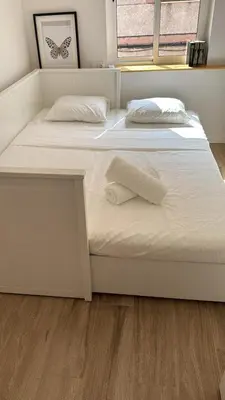 two white beds in a bedroom with a wooden floor at Large New House with Terraces and Air Conditioning in Cullera
