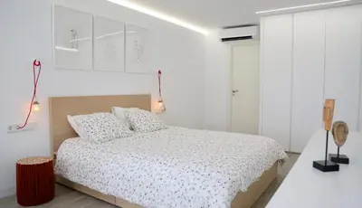 a white bedroom with a bed and white cabinets at Austria 4 in Valencia
