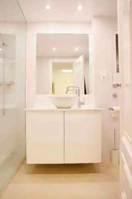 a white bathroom with a sink and a mirror at Austria 4 in Valencia