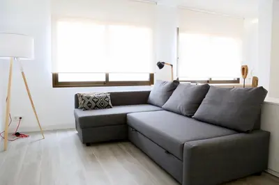a gray couch in a living room with two windows at Austria 4 in Valencia