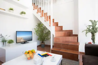 a living room with a table and a tv at SingularStays Botanico29 in Valencia
