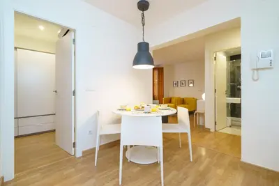 a kitchen and dining room with a white table and chairs at Valencia Home Carmen in Valencia