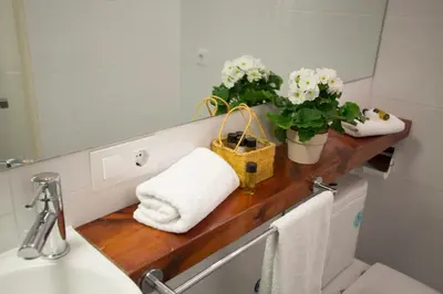 a bathroom with a wooden counter with towels and flowers at SingularStays Botanico 29 Rooms in Valencia