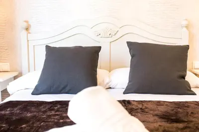 a bedroom with a white bed with blue pillows at Total Valencia Old City Luxury in Valencia