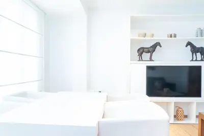 a white living room with two white chairs and a tv at Valencia Luxury - Boutique Center in Valencia