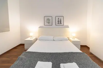 a bedroom with a large white bed with two night stands at Down Town in Valencia