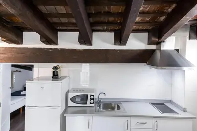 a kitchen with white appliances and wooden ceilings at Down Town in Valencia