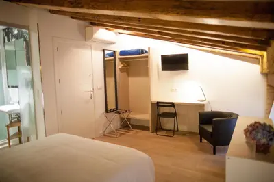 a bedroom with a bed and a desk and a tv at Host & Home in Valencia