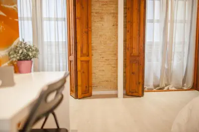 a room with a table and a chair and windows at Host & Home in Valencia