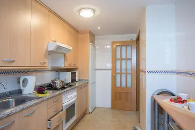 a kitchen with wooden cabinets and a sink at SingularStays Artes in Valencia