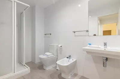 a white bathroom with a toilet and a sink at Travel Habitat Ayuntamiento in Valencia