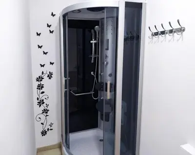 a shower in a bathroom with black butterflies on the wall at Flats Friends Plaza de la Reina in Valencia