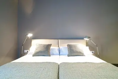 a bed with two pillows and two lights on it at Valencia Luxury - Boutique Paz in Valencia
