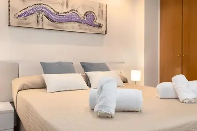 a bedroom with two beds with white towels on them at ApartUP Patacona Beach I in Valencia