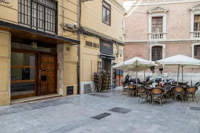 an outdoor patio with tables and chairs and umbrellas at Travel Habitat Teatro Principal in Valencia