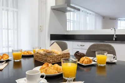a table with plates of pastries and cups of orange juice at Travel Habitat Teatro Principal in Valencia