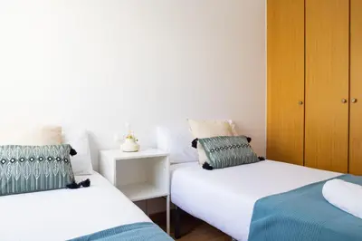 a bedroom with two beds and a wooden cabinet at Medinaceli airco, wifi and free parking in Valencia