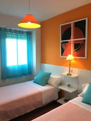 a bedroom with two beds and a window and a lamp at Apartamento PuigVal in El Puig