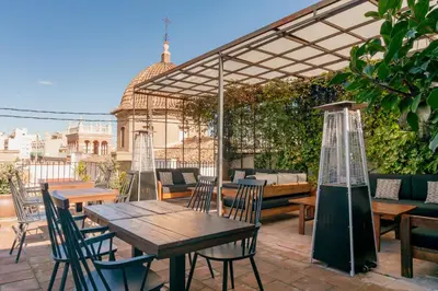 a patio with tables and chairs under a pergola at The Valentia Cabillers in Valencia