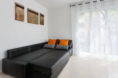 a black leather couch in a room with a window at My Loft 4 You Na Jordana in Valencia