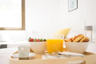 a breakfast table with a bowl of food and a glass of orange juice at Xativa Terrace II in Valencia