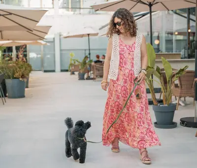 a woman walking a black poodle on a leash at Hotel Barú in Sagunto