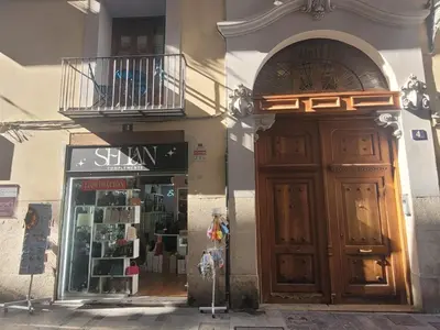 a building with a large wooden door and a store at Living Valencia Peydro in Valencia